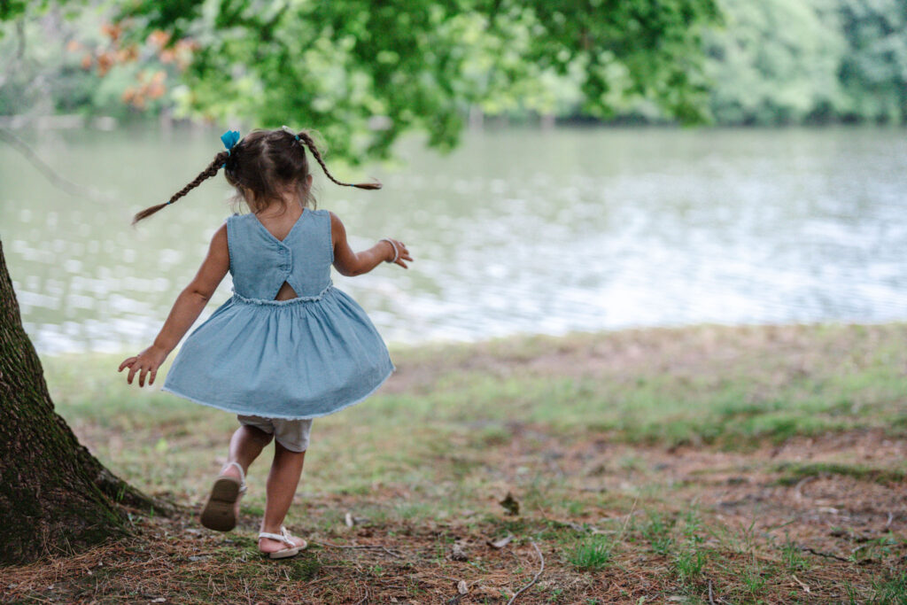 Little girl is dancing during a lifestyle outdoor family photography session by Ivy Lulu Photography in Metrowest Massachusetts