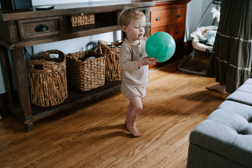 The little boy is playing a ball during a newborn photography session
