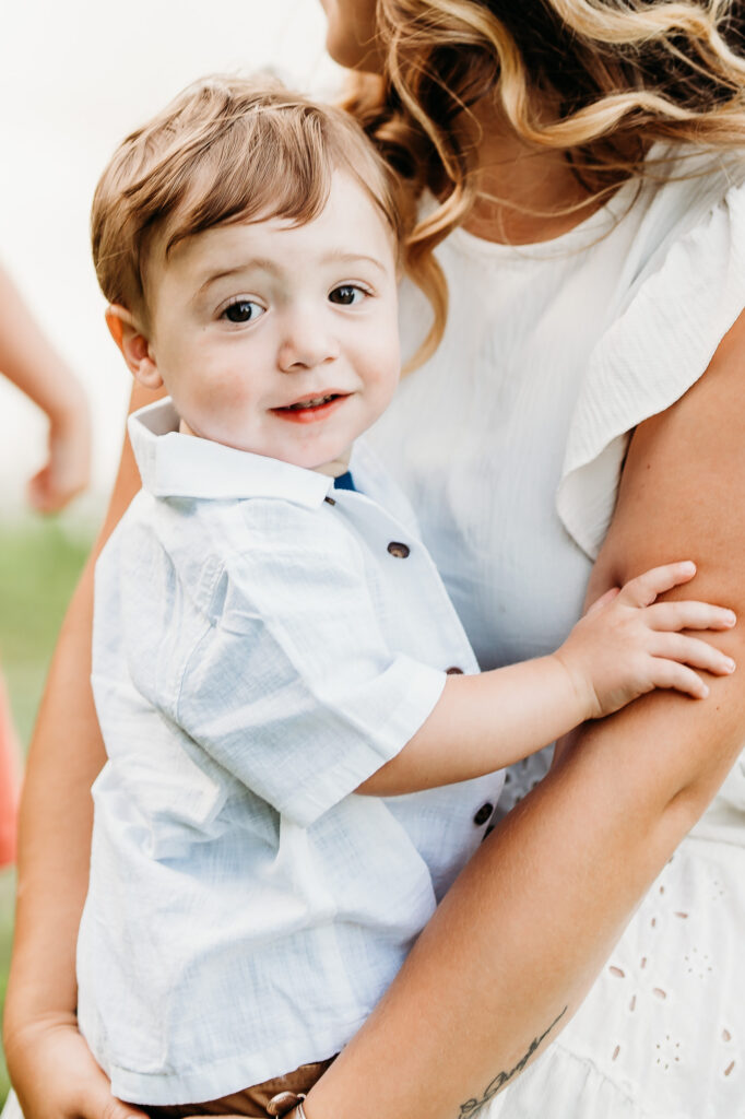 The little boy is looking at camera during a lifestyle family photography session in Massachusetts