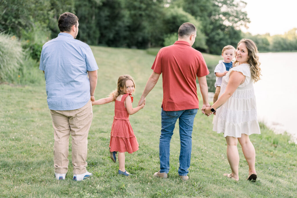 Family members are holding hands and walking together during a lifestyle family photography session in Massachusetts