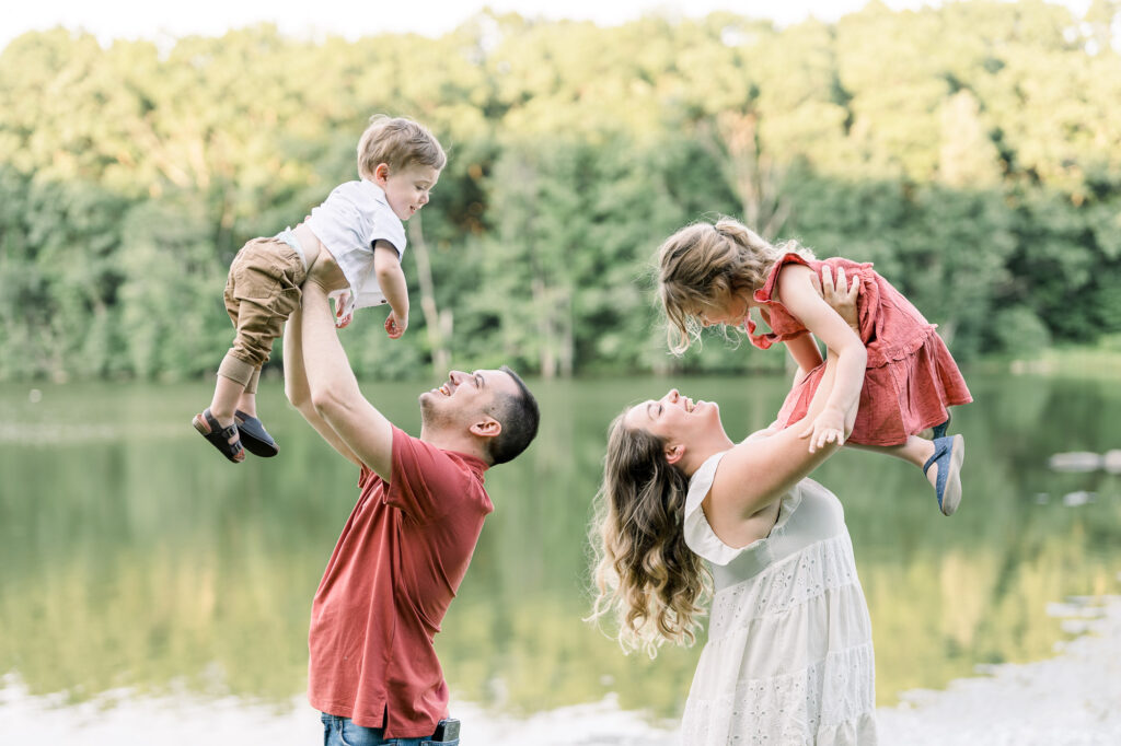 Parents are holding the children up to the air during a lifestyle family photography session in Shrewsbury Massachusetts